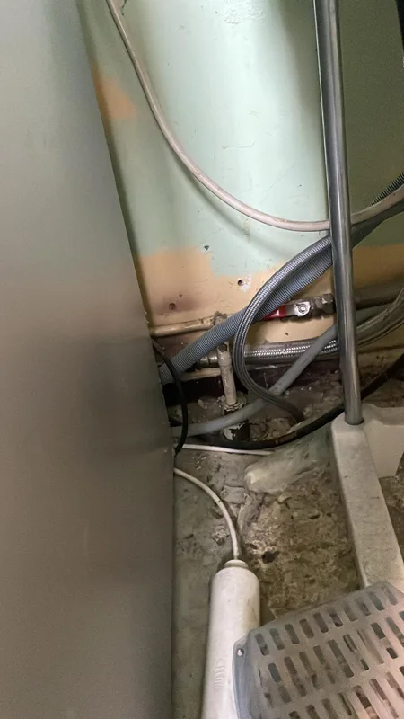Flexibles et arrivée d'eau vétustes derrière un appareil ménager